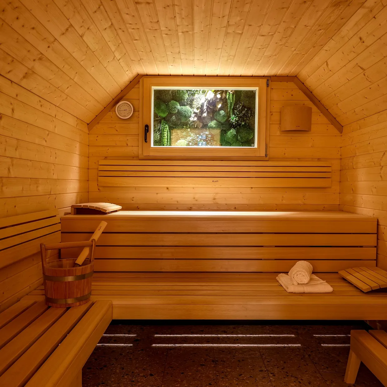 Holzraum mit Bänken, Fenster und Eimer, erhellt von sanftem Licht