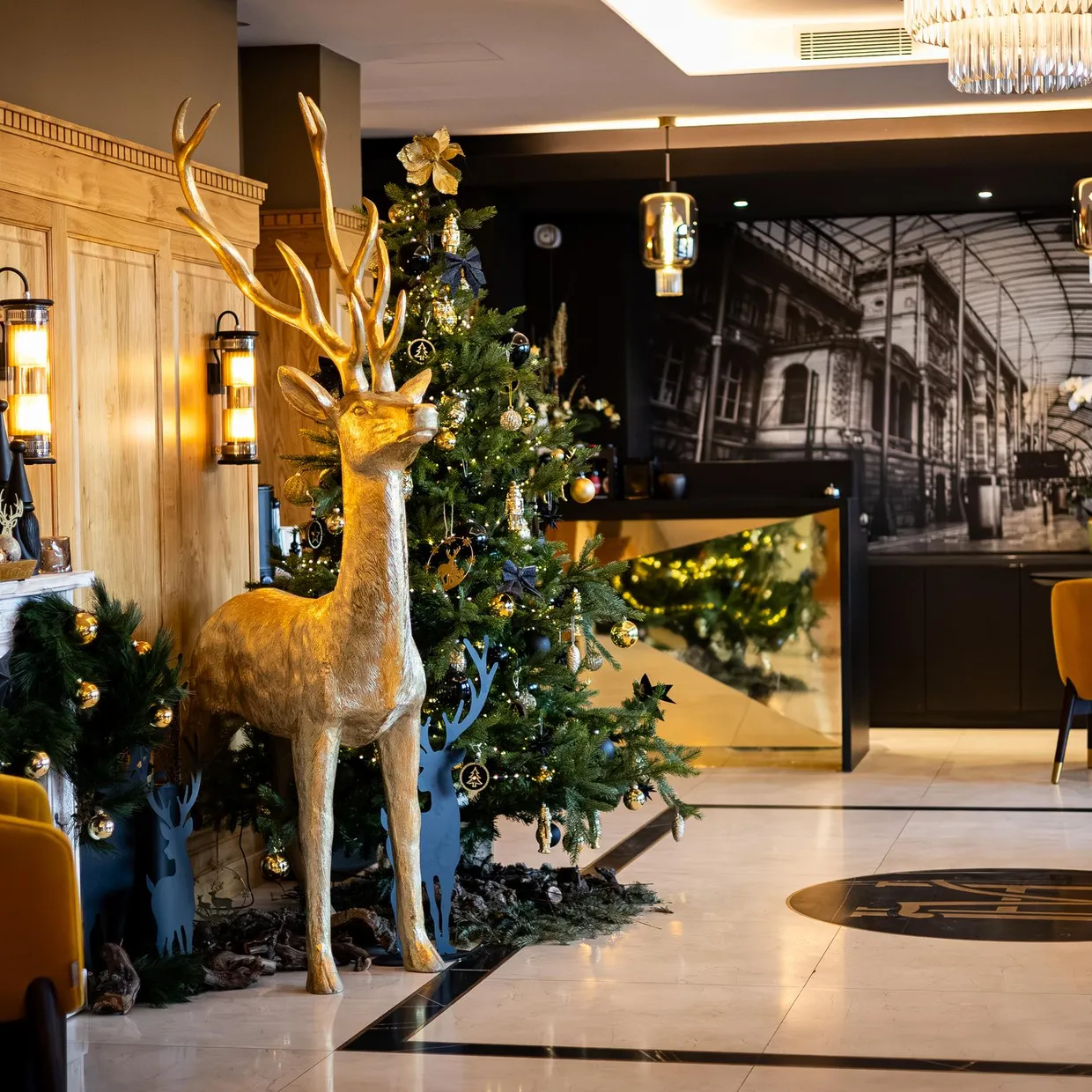 Ein für Weihnachten dekoriertes Interieur mit einem Tannenbaum, einem goldenen Hirsch und gelben Sitzen