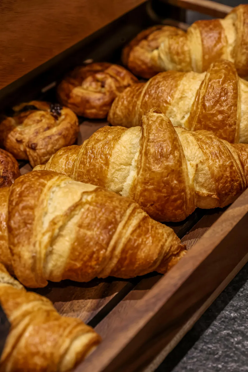 A wicker basket containing golden, flaky croissants