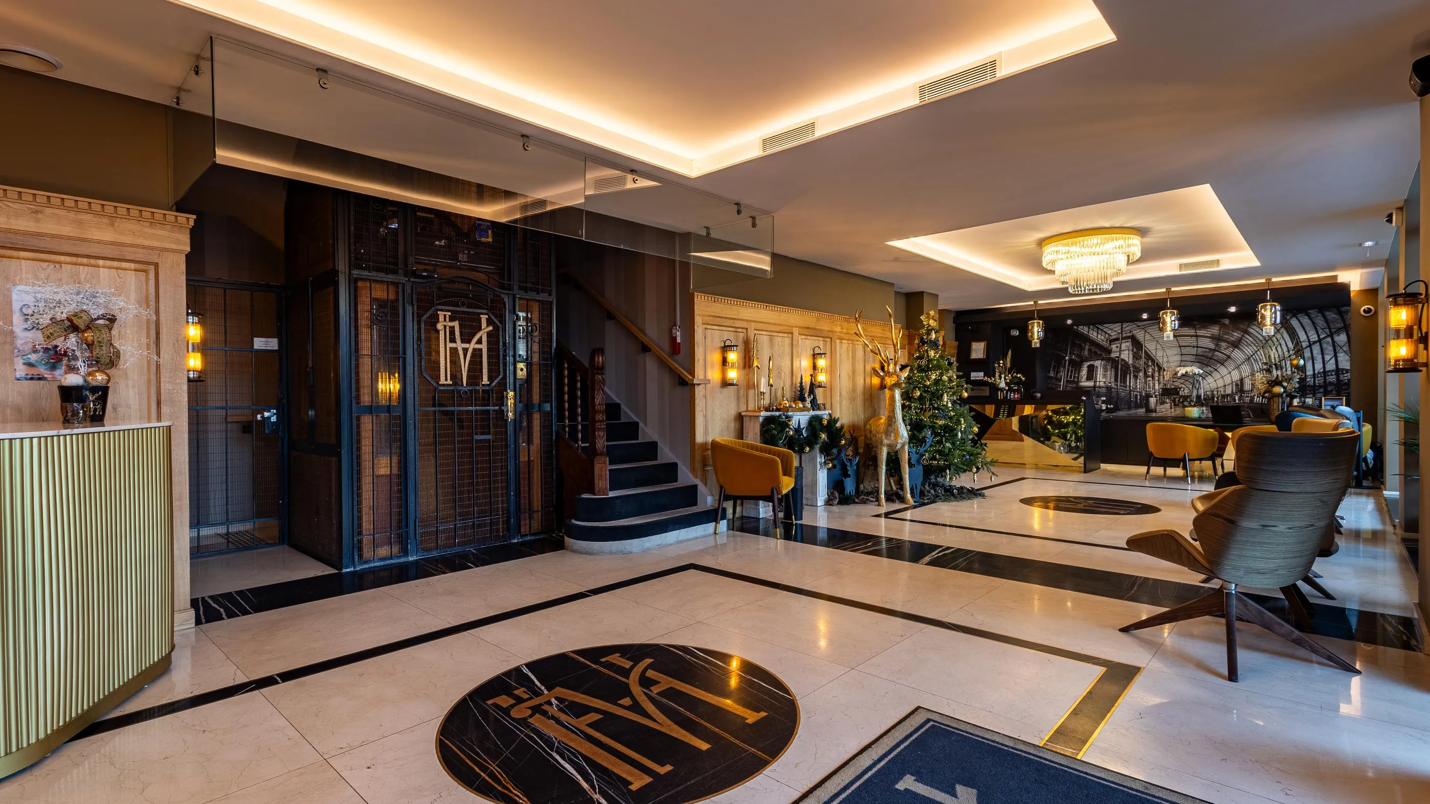 Hotellobby mit Bar, Sesseln, Weihnachtsdekoration und einer zentralen Treppe